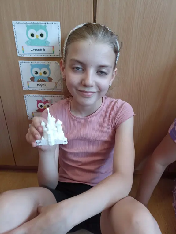 zdjęcie uczennicy, trzymającej druk 3d