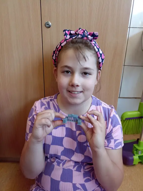 zdjęcie uczennicy, trzymającej druk 3d