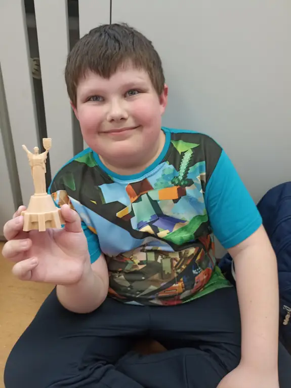 zdjęcie ucznia, trzymającego druk 3d