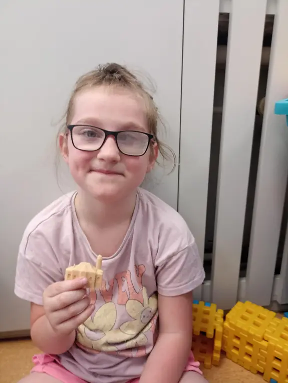 zdjęcie uczennicy, trzymającej druk 3d