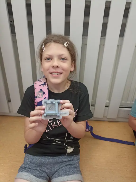 zdjęcie uczennicy, trzymającej druk 3d