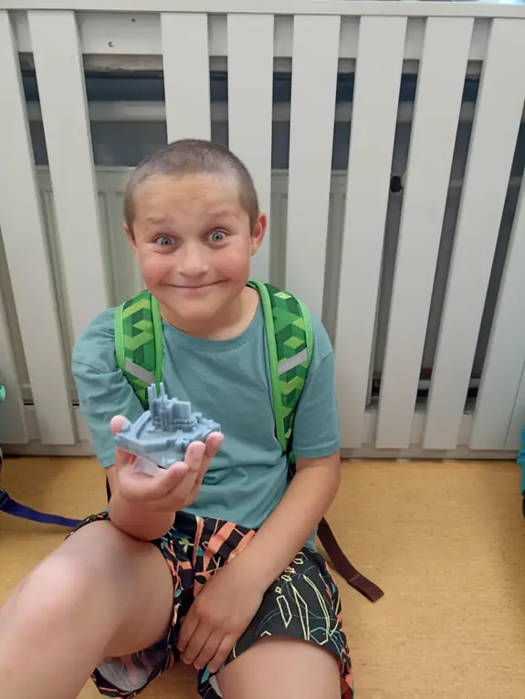 zdjęcie ucznia, trzymającego druk 3d