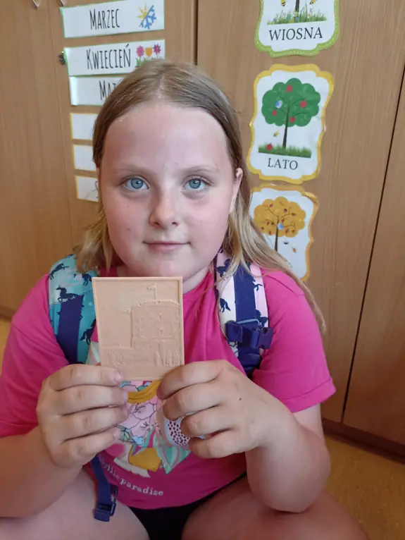 zdjęcie uczennicy, trzymającej druk 3d